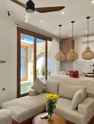 a living room with a couch and a ceiling fan at Villa Boginville in Kerobokan