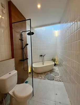 a bathroom with a toilet and a bath tub at Villa Boginville in Kerobokan