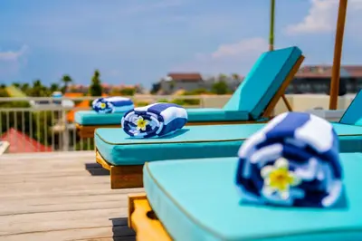 a row of blue lounge chairs on a playground at Avanya Luxury Apartment by Pertama Management in Seminyak