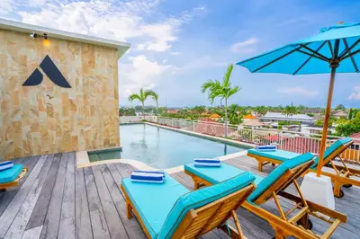 a patio with a pool and chairs and an umbrella at Avanya Luxury Apartment by Pertama Management in Seminyak