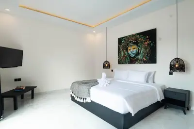 a bedroom with a bed with a painting on the wall at Stylish Umalas 2BR Villa With Private Pool in Kerobokan