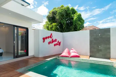 a swimming pool in a house with red writing on the wall at Stylish Umalas 2BR Villa With Private Pool in Kerobokan
