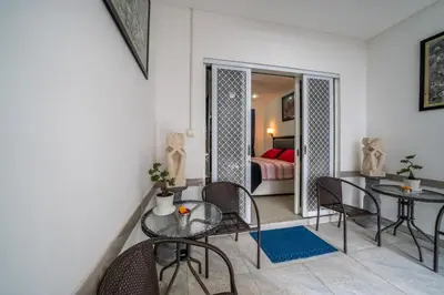 a living room with a table and chairs and a bedroom at KUTA - 3 Bedroom Private Pool Villa on Jl Mataram! in Kuta