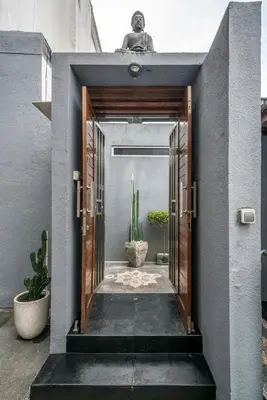 an open door into a courtyard with potted plants at KUTA - 3 Bedroom Private Pool Villa on Jl Mataram! in Kuta