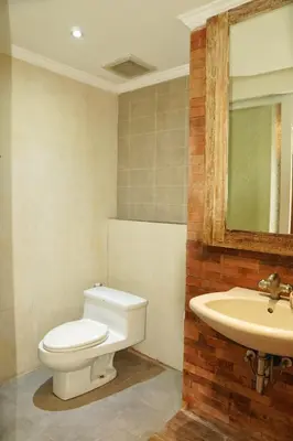 a bathroom with a toilet and a sink at Koura Jimbaran in Badung