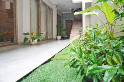 a corridor of a building with plants at Koura Jimbaran in Badung