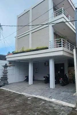 a white house with motorcycles parked in front of it at Koura Jimbaran in Badung
