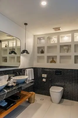 a bathroom with a toilet and two sinks and a mirror at Kiara Ocean Place in Canggu