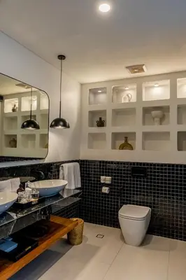 a bathroom with a toilet and two sinks and a mirror at Kiara Ocean Place in Canggu