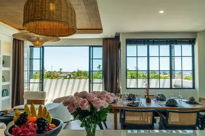 a dining room with a table with a bowl of flowers at Kiara Ocean Place in Canggu