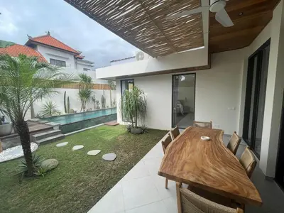 a dining room with a wooden table in a house at Cozy 3 Bedrooms Villa Umalas in Kerobokan