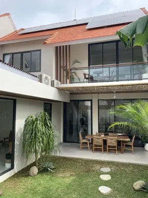 a house with a table and chairs in front of it at Cozy 3 Bedrooms Villa Umalas in Kerobokan