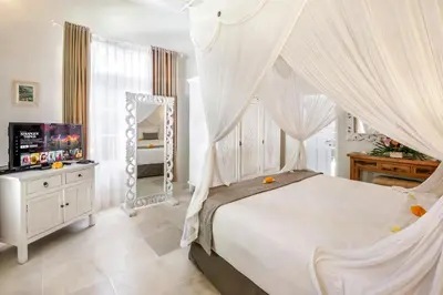 a bedroom with a canopy bed and a mirror at Villa Lodek Deluxe in Seminyak