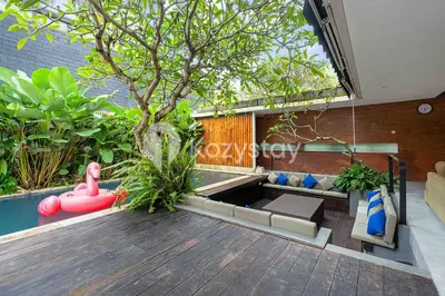 a living room with a pool and a tree at Bamila Villa by Kozystay - Umalas in Canggu