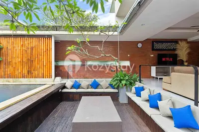 a living room with a couch and a swimming pool at Bamila Villa by Kozystay - Umalas in Canggu
