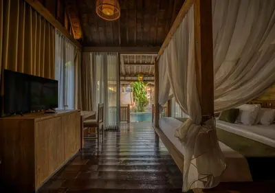 a bedroom with a bed and a television in it at Natajiwa Village close to Canggu and Seminyak in Seminyak