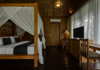 a bedroom with a bed and a desk and a television at Natajiwa Village close to Canggu and Seminyak in Seminyak