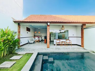 a villa with a swimming pool and a house at Sejati Villas - Petitenget in Seminyak