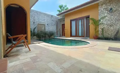 a swimming pool in the courtyard of a house at The Kutata in Jimbaran