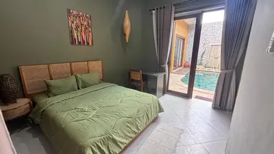a bedroom with a bed and a door to a pool at The Kutata in Jimbaran