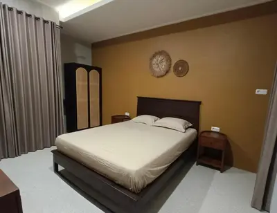 a bedroom with a bed and a clock on the wall at The Kutata in Jimbaran