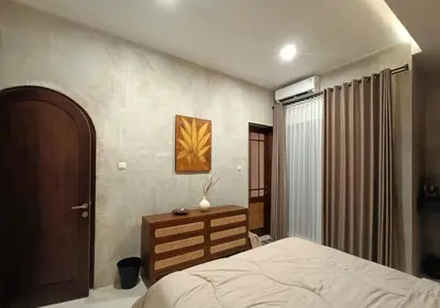 a bedroom with a bed and a dresser at The Kutata in Jimbaran