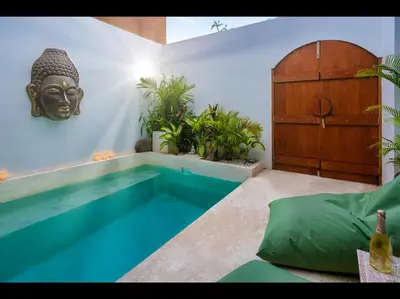 a room with a swimming pool with a head on the wall at Villa Kembar in Seminyak