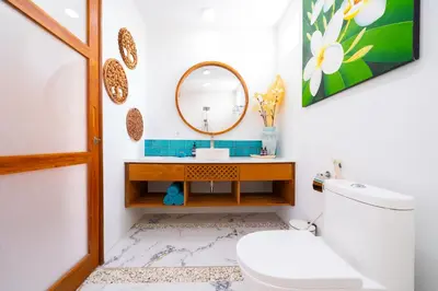 a bathroom with a mirror and a toilet at Villa Kembar in Seminyak