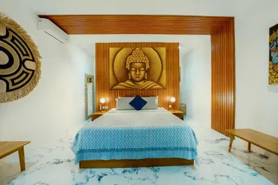 a room with a bed with a large buddha mural at Villa Kembar in Seminyak
