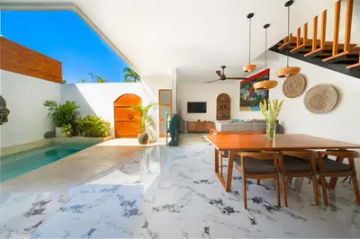 a dining room with a table and a swimming pool at Villa Kembar in Seminyak