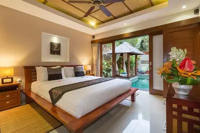 a bedroom with a large bed and a large window at Villa Green Manggo Seminyak Bali in Seminyak
