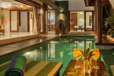 a swimming pool with a table and glasses in a house at Villa Green Manggo Seminyak Bali in Seminyak