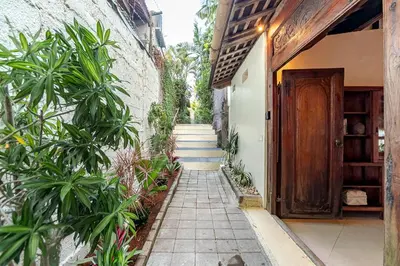 a pathway leading to a house with a wooden door at Villa Madah - Secluded & Romantic Retreat 1BR Near Umalas with Private Pool & View in Kerobokan