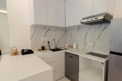 a white kitchen with white cabinets and a sink at Cozy Seminyak Loft 360 Sweet in Seminyak