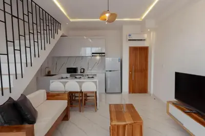 a living room with a couch and a kitchen at Cozy Seminyak Loft 3 Bedroom Private Villa in Seminyak