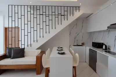 a living room with a white couch and a table at Cozy Seminyak Loft 3 Bedroom Private Villa in Seminyak