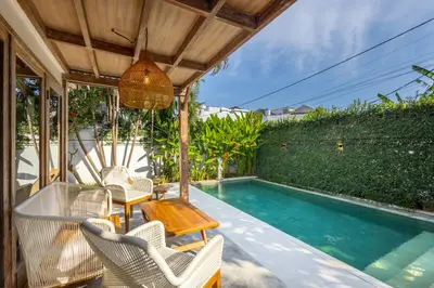 a patio with chairs and a swimming pool at Villa Vintage 3 in Canggu
