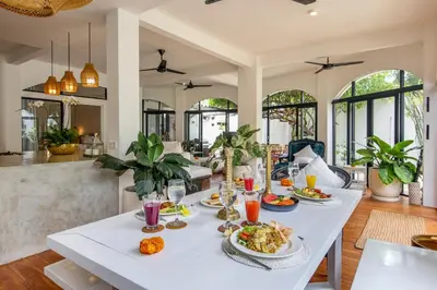 a dining room with a white table with food on it at Villa Roma in Seminyak