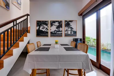 a dining room with a table and chairs and a pool at Villa Boswellia Seminyak near Double Six Beach in Seminyak