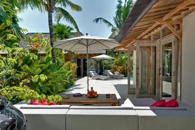 an outdoor patio with an umbrella and a table at Kudus Boutique Estate in Canggu 100m to Beach in Canggu