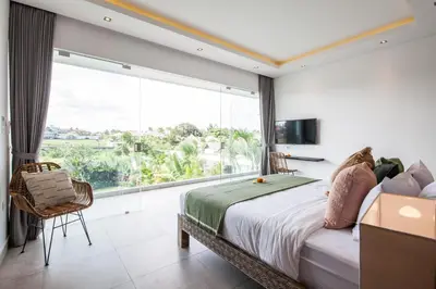 a bedroom with a bed and a large window at Villa Elisa in Canggu