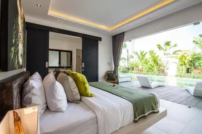 a bedroom with a large bed and a large window at Villa Elisa in Canggu
