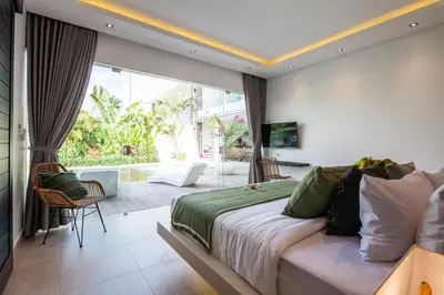 a bedroom with a large bed and a balcony at Villa Elisa in Canggu
