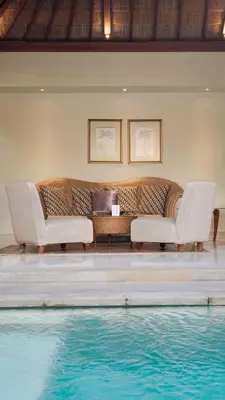 a living room with a couch and a swimming pool at Jepun Villa by Betterplace in Seminyak