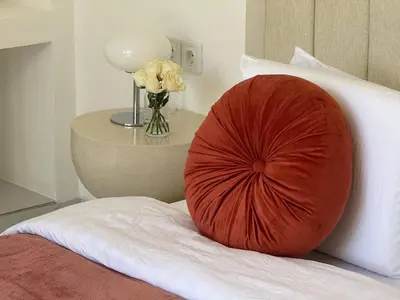 a large red pillow on a bed with a vase of flowers at LUX 2 Bed Villa - Berawa in Canggu
