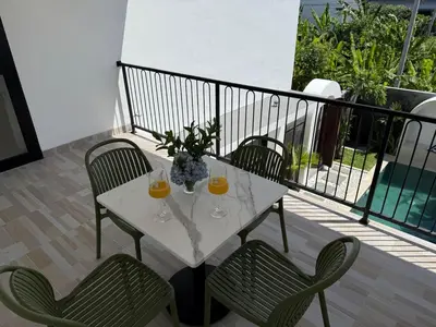 a table with two glasses of orange juice on a balcony at LUX 2 Bed Villa - Berawa in Canggu