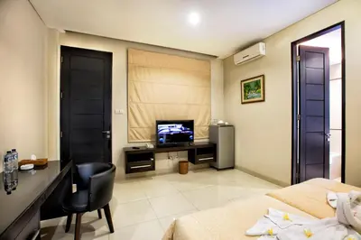 a bedroom with a desk and a television in a room at InKuta Residence and Villa in Seminyak