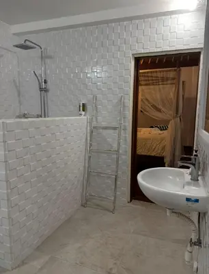 a bathroom with a sink and a shower and a bed at White Sands Private Villa in Seminyak