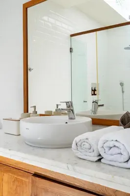 a bathroom with a sink and a large mirror at Beta Stay and Surf in Canggu