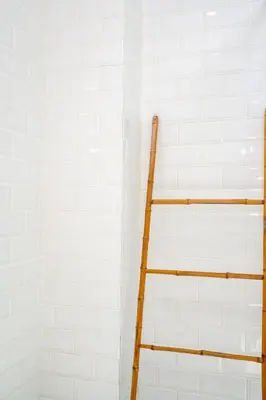 a ladder is next to a white tiled wall at Beta Stay and Surf in Canggu